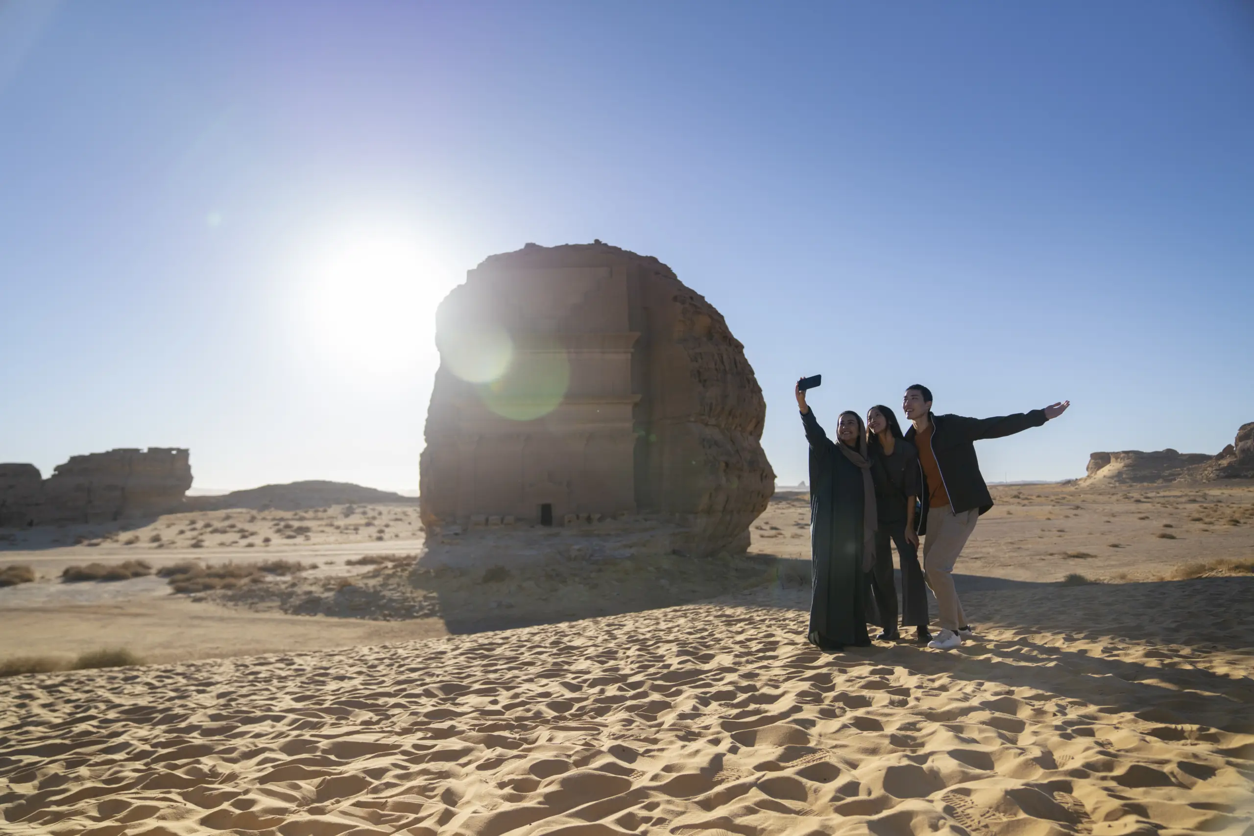 A group of adults capturing a selfie in front of the ancient car