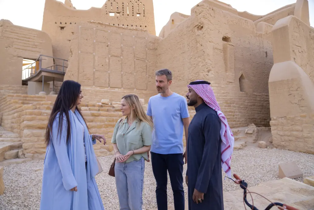 A group of adults having a conversation outside the Salwa Palace
